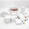 A luxury all-white soft play setup featuring a chic ball pit, white foam climbing blocks, and a mini slide on a clean white play mat
